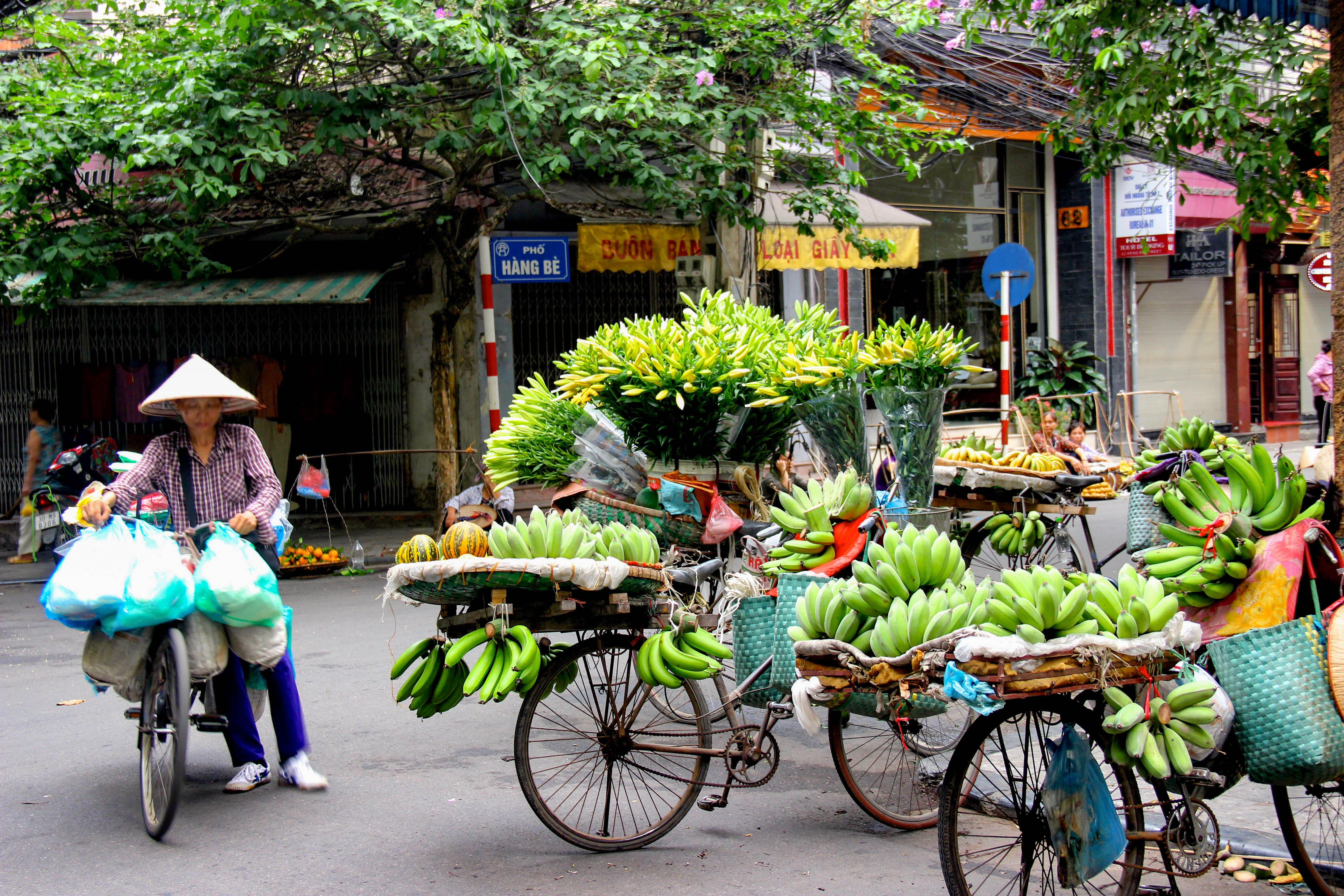 Voyage à moto au Vietnam : vendeuse dans la vieille ville de Hanoi Vendeuse dans une rue de la vieille ville de Hanoi au Vietnam
